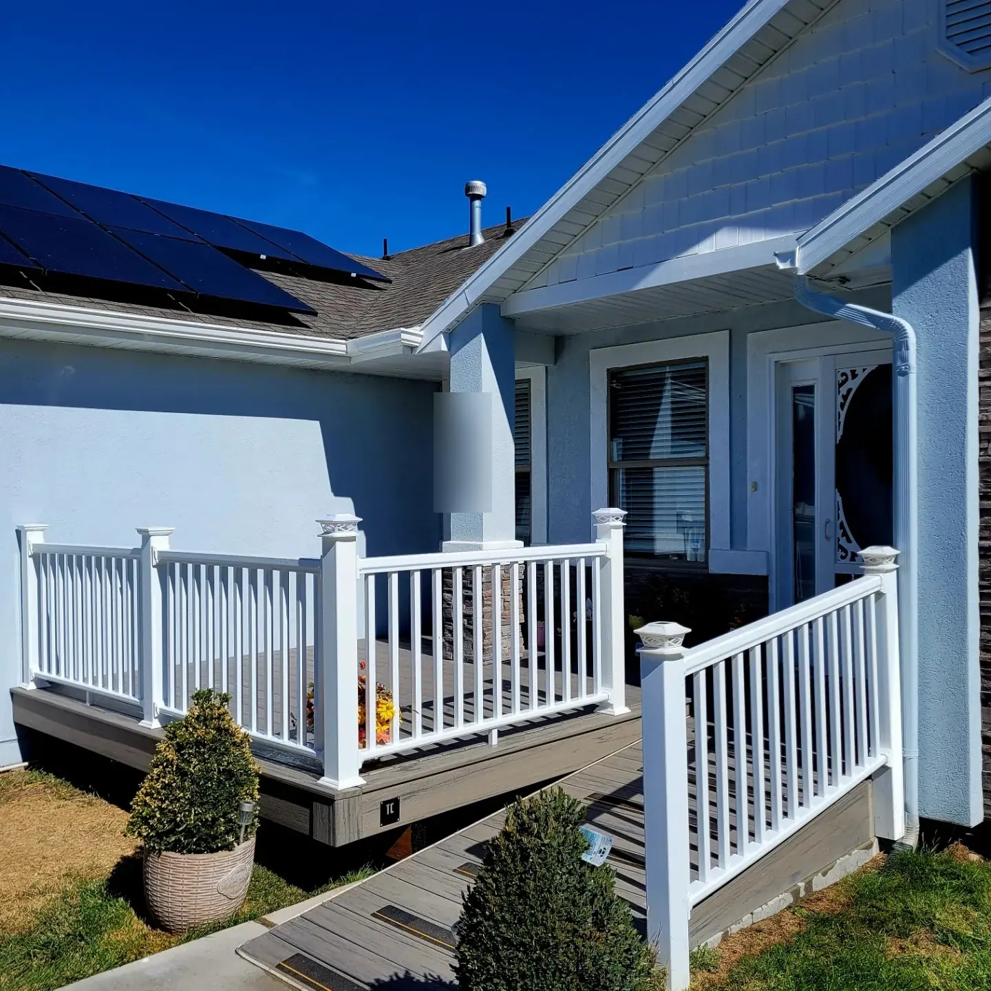 Composite front porch and walkway with white railing built by TC Decks