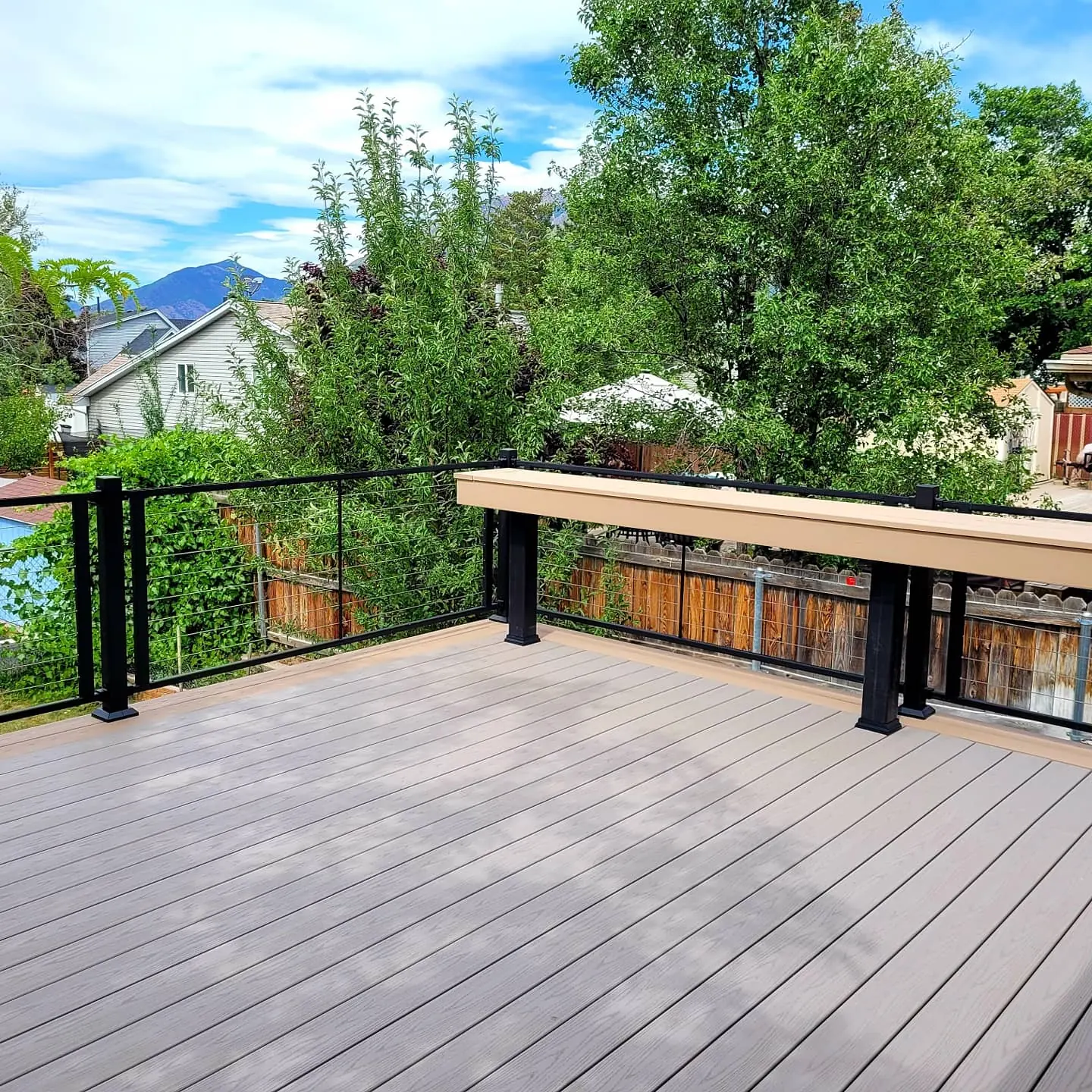 Composite bench along black railing on a deck