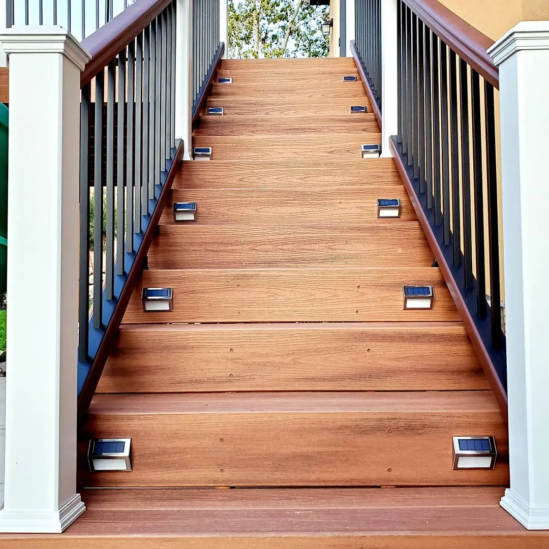 Hardwood deck stairs with riser lights and white posts