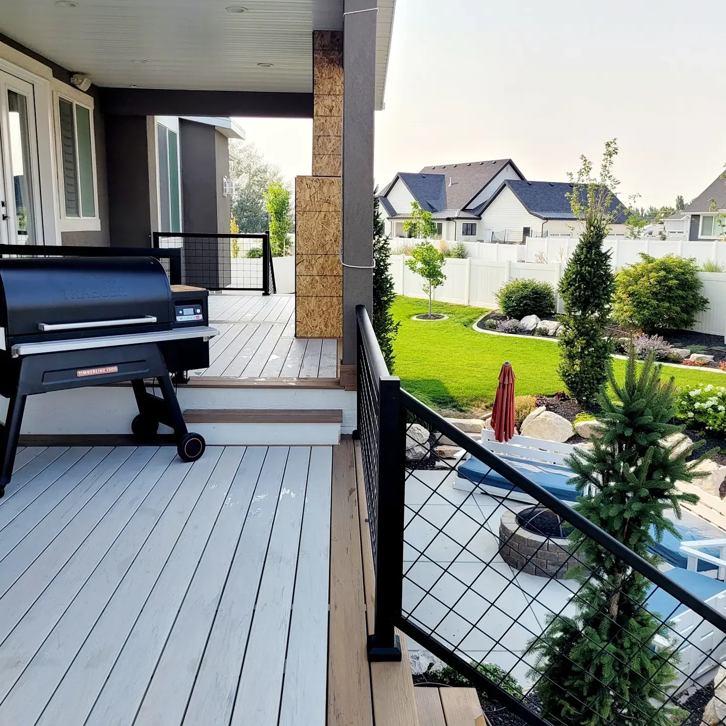 Light gray composite deck with cable railing next to a pool