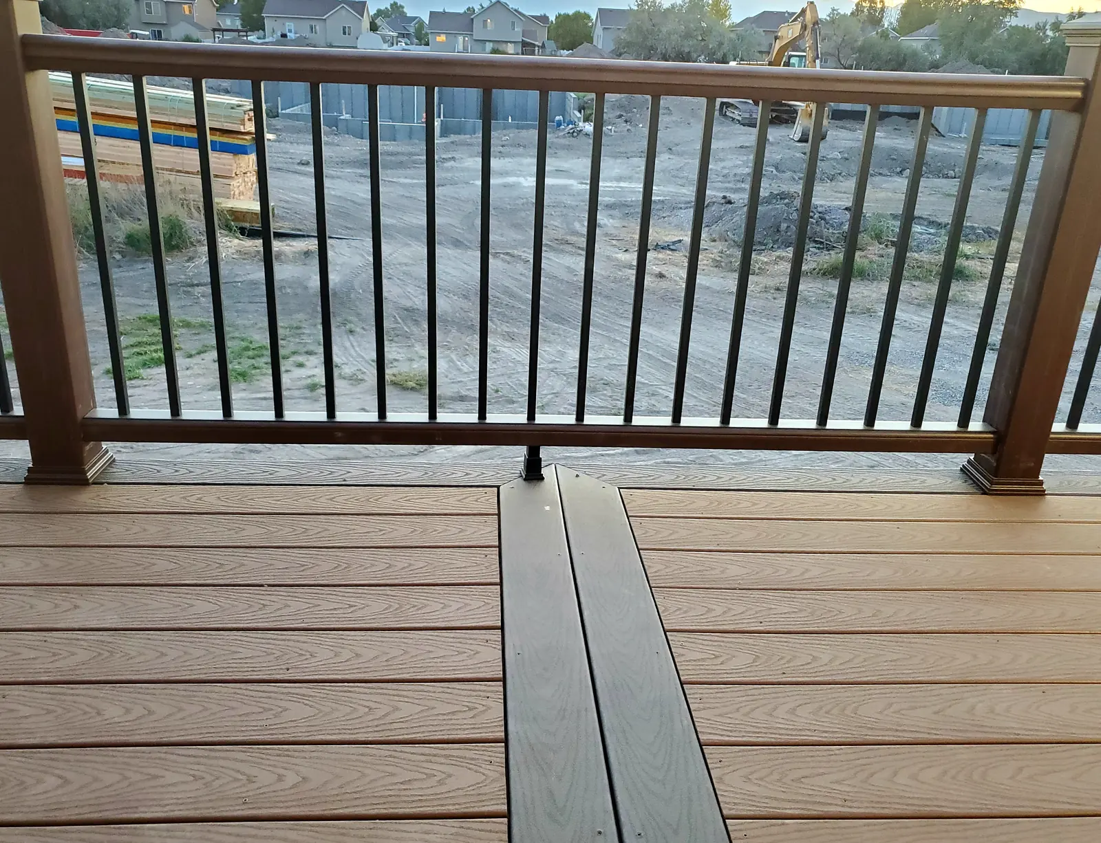 Two-tone composite decking with a contrasting border and wood-look railing
