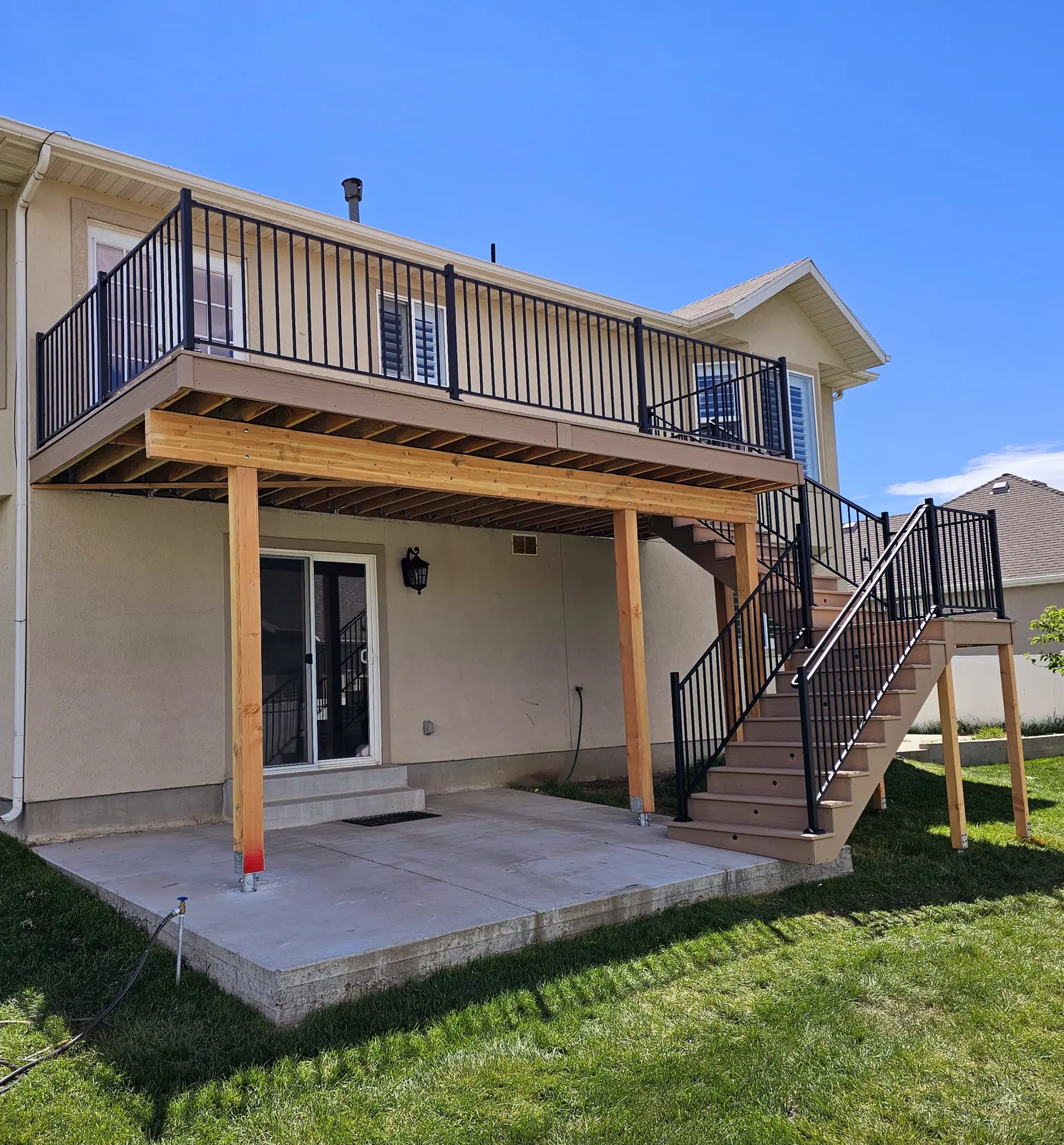 Second-story deck with a patio below and a long stair