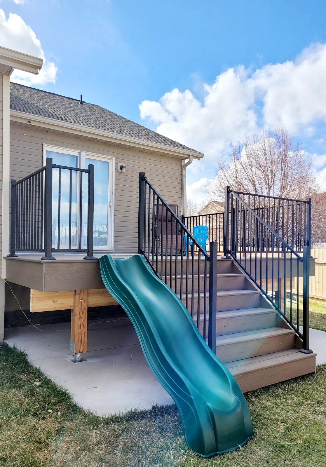 Deck stairs and a green slide down to the lawn