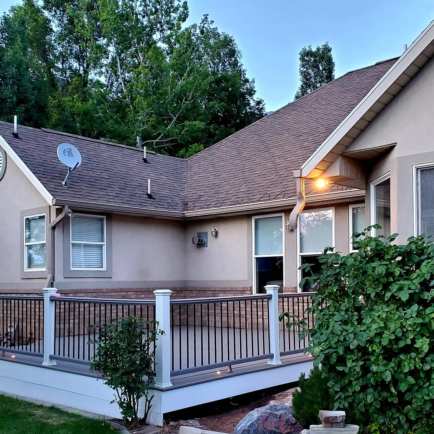 Trex deck with white railing posts wrapping the back of a Lindon home