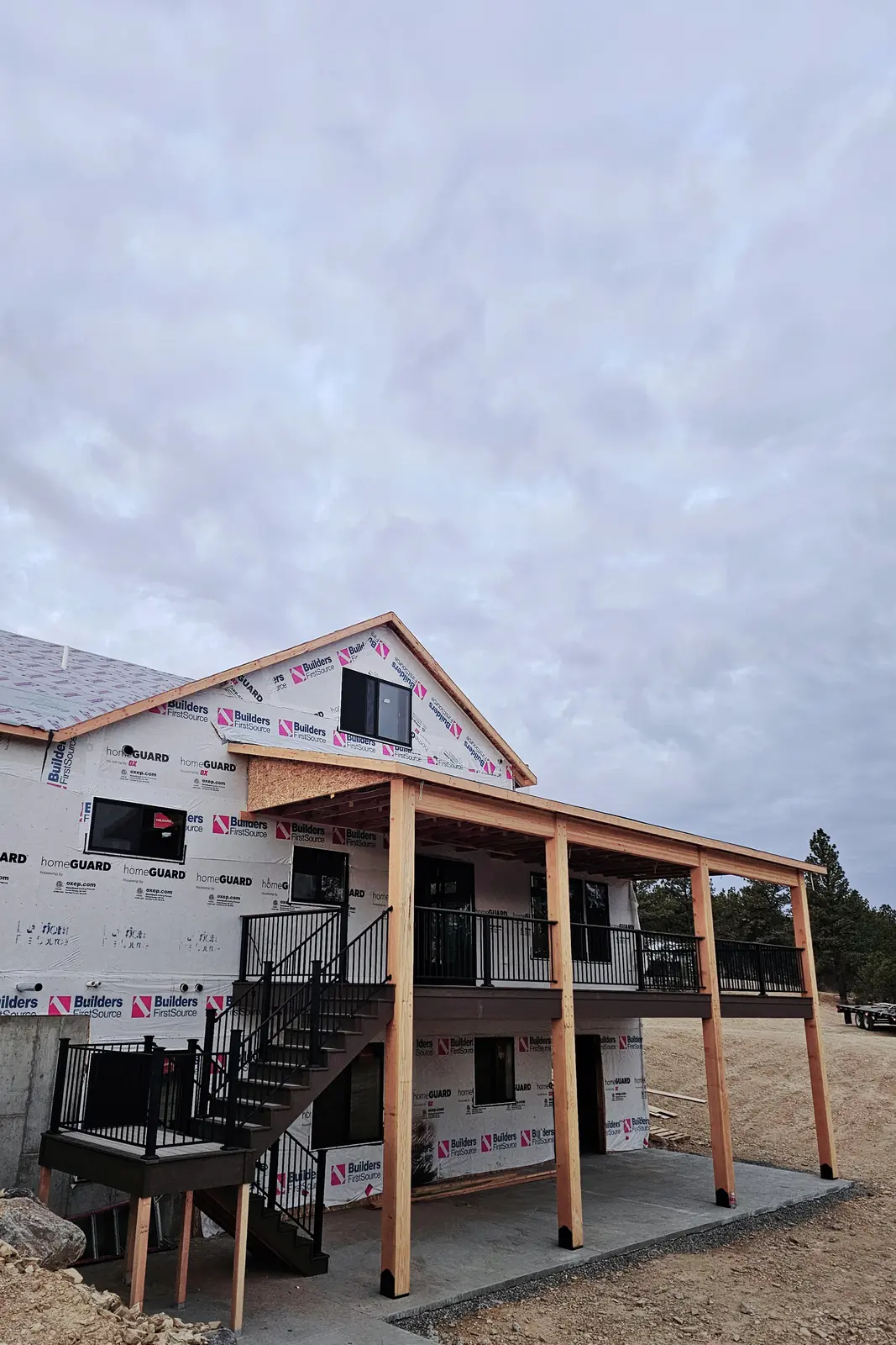 Switchback stairs with black aluminum railing leading to a covered second-story deck