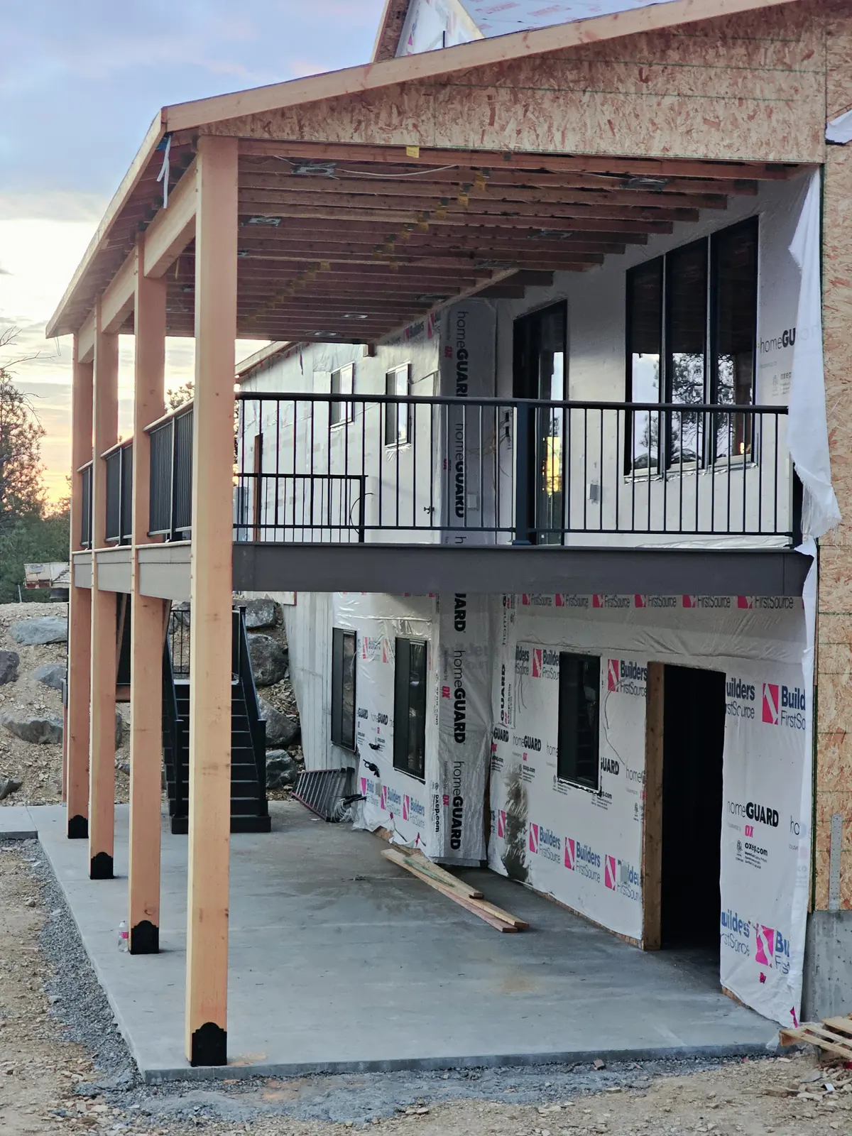 Timber-framed roof over a second-story deck with a covered patio underneath