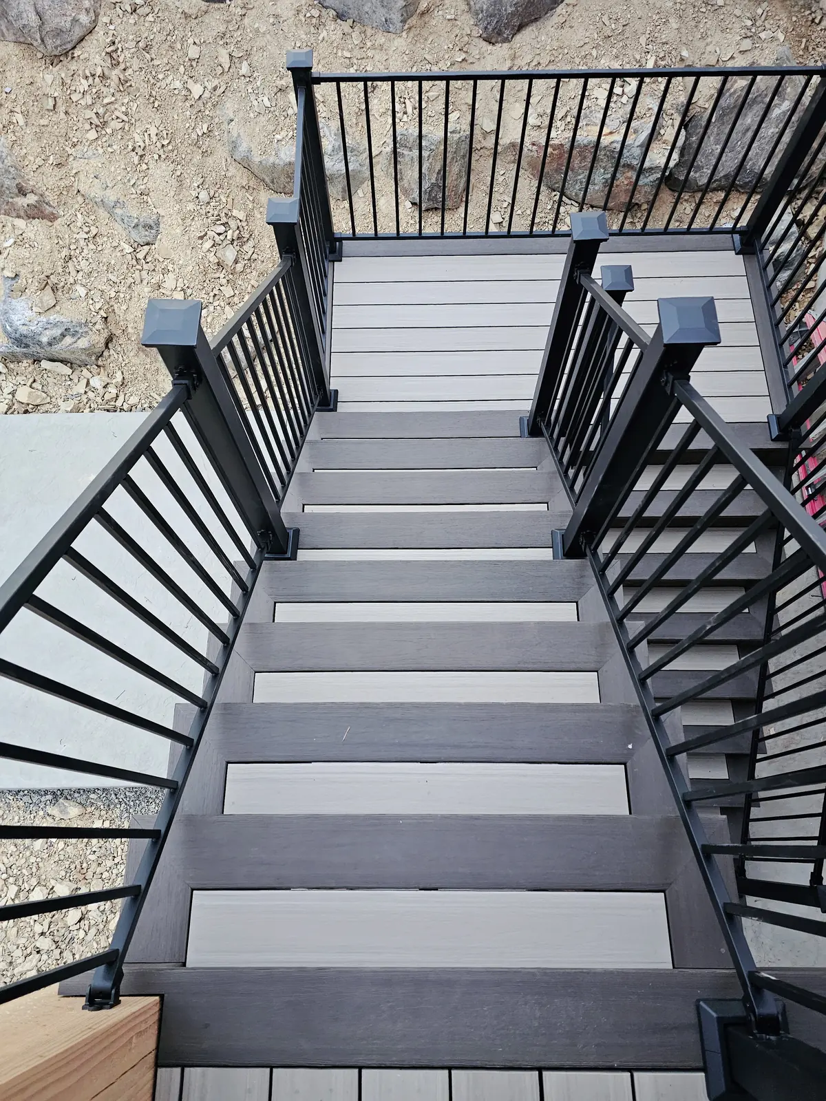 Composite stairs and landing with two-tone treads and black Fortress steel railing