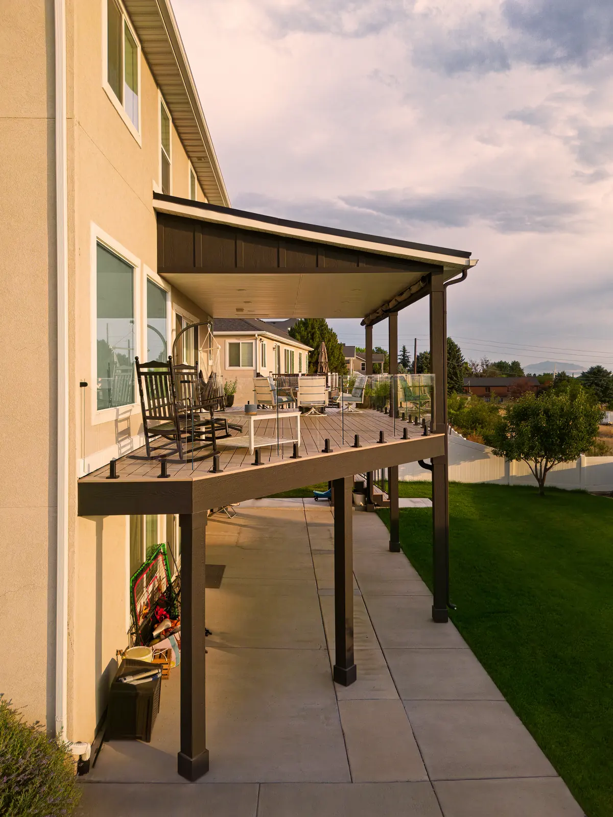 Side view of a covered second-story deck with glass railing