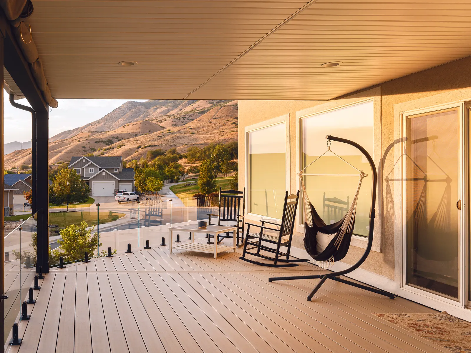 TimberTech French White Oak covered deck with a hanging chair and rocking chair