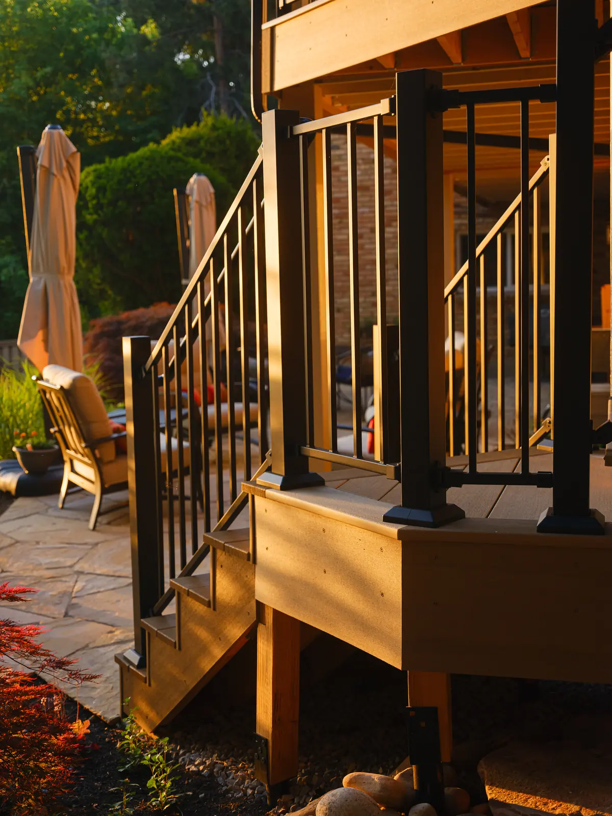 Deck stair landing with black aluminum railing