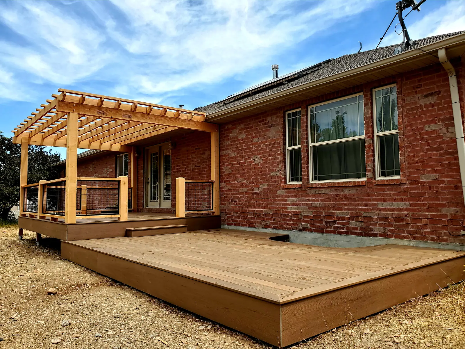 Low TimberTech deck with a curved cutout around a basement window well