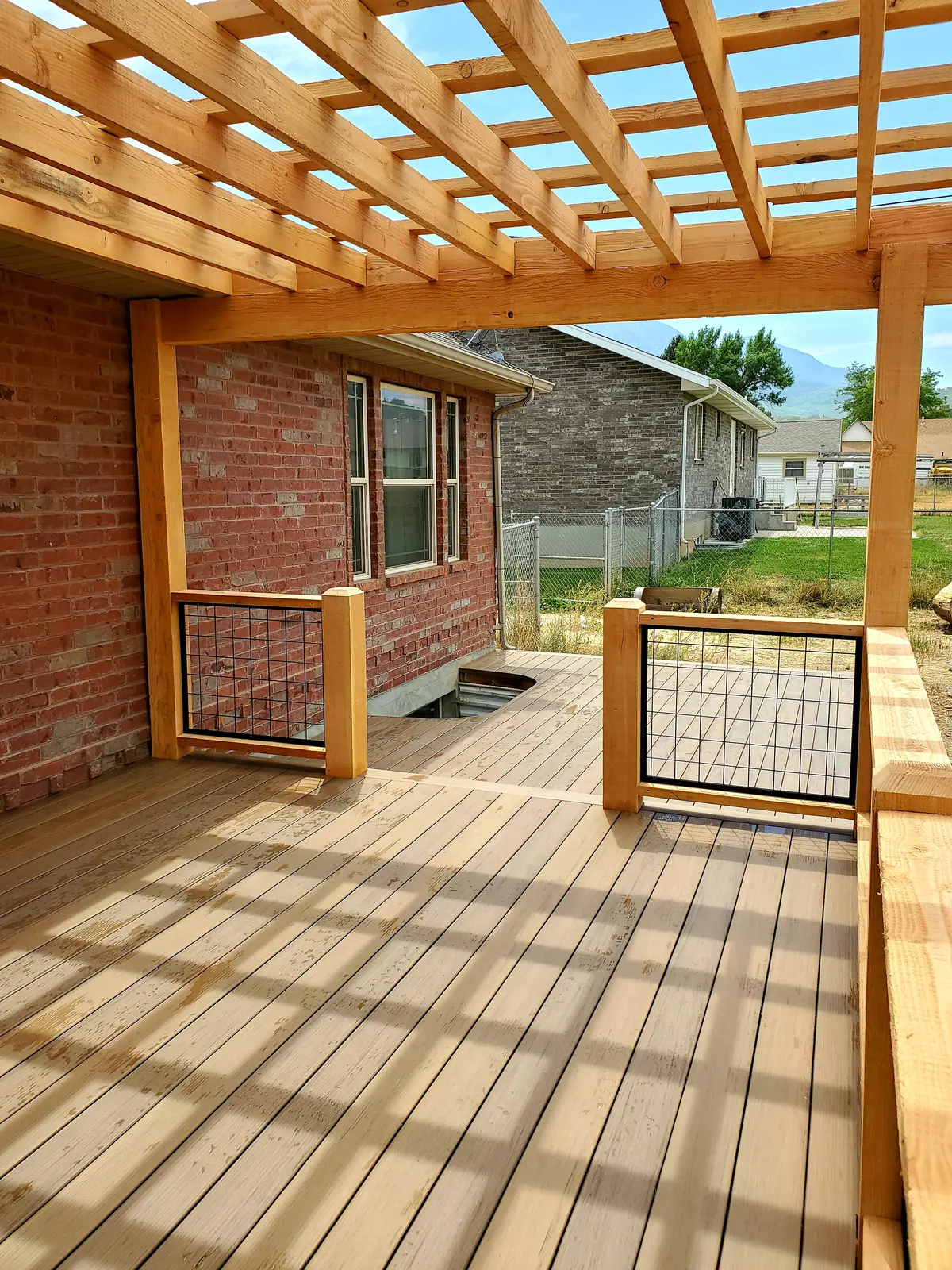 Pergola shade on a Pecan deck with a cutout around the window well