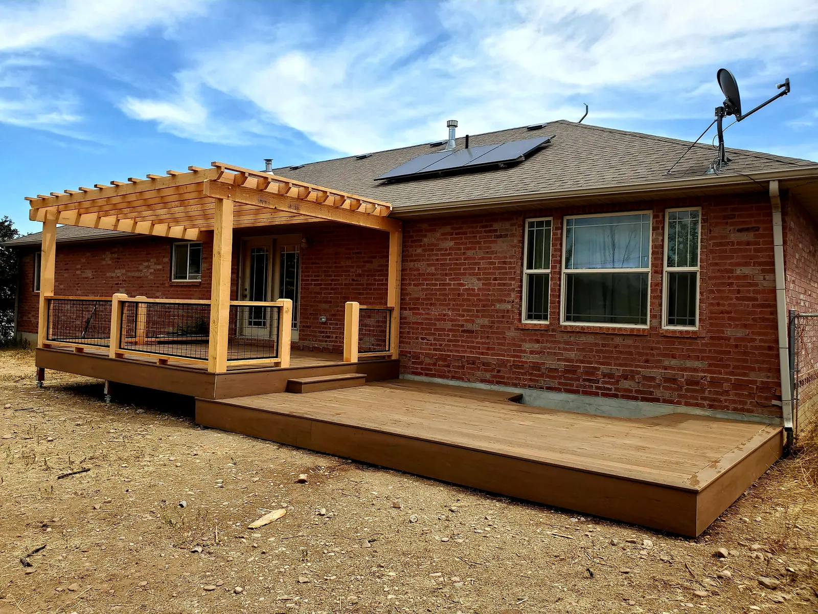 Upper deck with pergola stepping down to a wide lower TimberTech Pecan deck