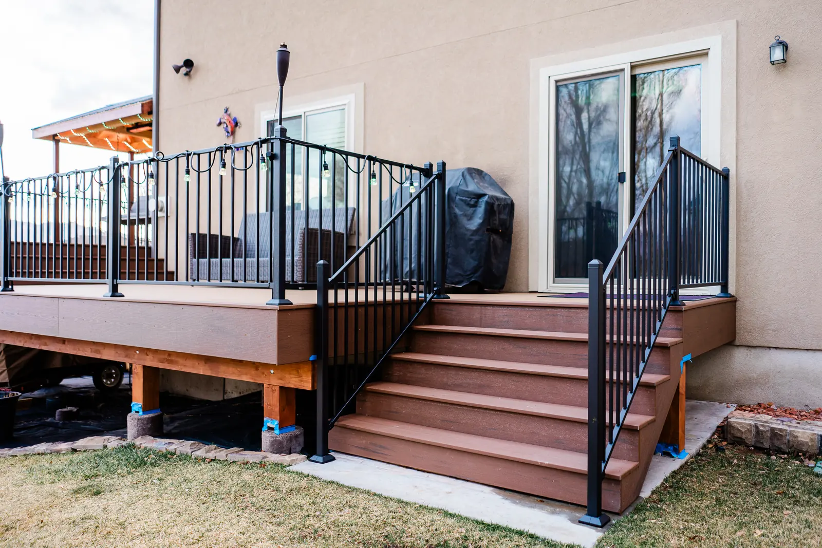 TimberTech Dark Cocoa stairs with black Fortress railing down to the yard